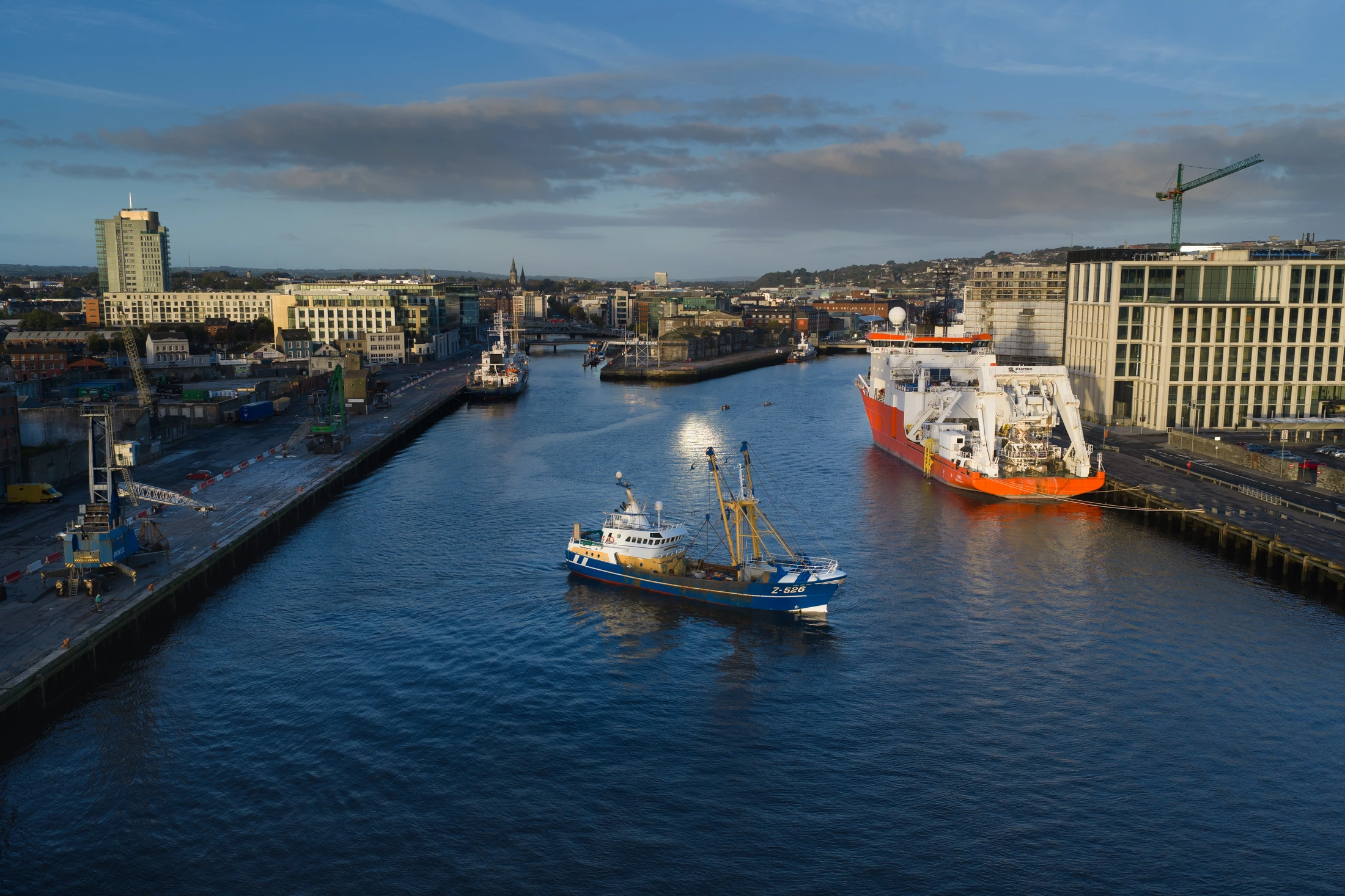 View along Cork's city docks towards the city, with ships and riverside buildings